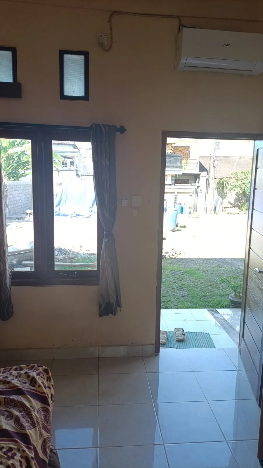 Interior kamar Standard Wisma Bludru dengan kasur, lemari, dan AC di Ubung Denpasar